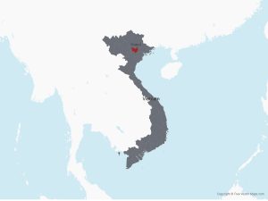 This map of Vietnam is a dark grey, with Hanoi highlighted in red. Vietnam is a long skinny country, with Hanoi situated in the northern region. On the east is the pacific ocean, on the west is a white landmass.