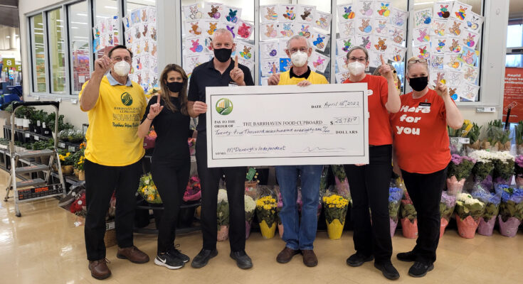 Six individuals hold a large cheque made out to the Barrhaven Food Cupboard while holding up one finger.