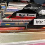 A cardboard record with a label saying Kanye West on it.