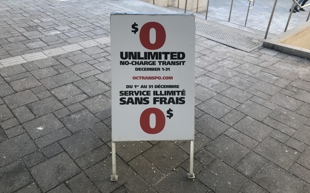 OC Transpo sign reads, “$0 unlimited no-charge transit. December 1-31.” in English and French.