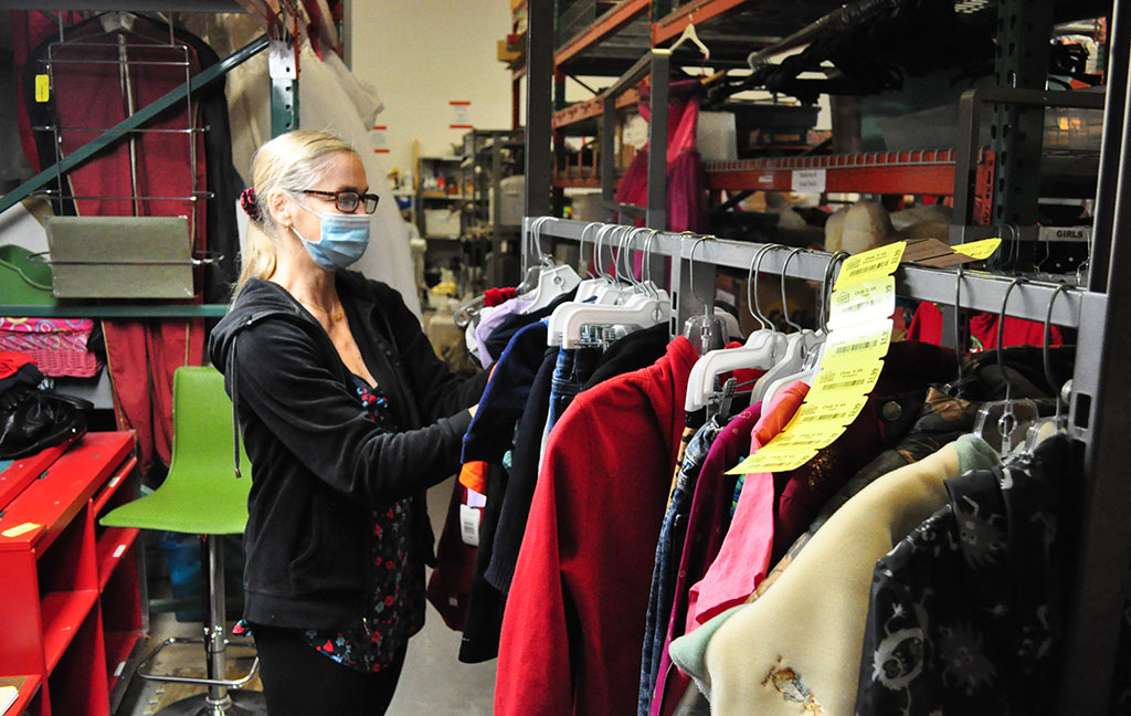 a woman tags clothes on a rack